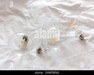 Three light bulbs on a white surface Stock Photo