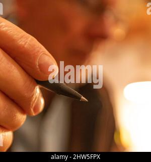 Close-up of mans hand holding pen Stock Photo