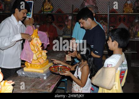 Mumbai Maharashtra India Asia Sep. 2007 Happy Indian Family Celebrating Ganesh Festival or Chaturthi Welcoming or performing Pooja in workshop Stock Photo