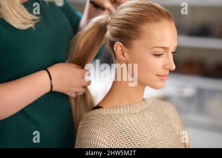 Finding that perfect hairdo. A young woman getting her hair done. Stock Photo