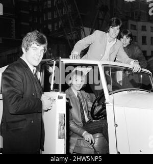 The Bee Gees examine an early christmas present from agent Robert Stigwood, a 1948 Rolls Royce Silver Wraith, 12th December 1967.  The car was given as a special gift to mark & celebrate reaching 1 million record sales of their single Massachusetts.  Four of the five members of the group look over the car & give it a polish and clean.   Mr Stigwood had the car completely re-upholstered and painted & teh engine was overhauled.  Pictured: Colin Peterson, Vince Melouney, Barry Gibb & Robin Gibb in Adams Row, Mayfair (Robin Gibb was not available for photo) Stock Photo