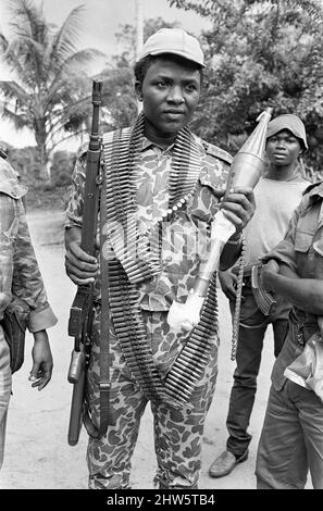 A Biafran soldier seen here holding an AK-47 assault rifle in one hand and a rocket propelled grenade in the other during the Biafran conflict. 11th June 1968. The Nigerian Civil War, also known as the Biafran War endured for two and a half years, from  6 July 1967 to 15 January 1970, and was fought to counter the secession of Biafra from Nigeria. The indigenous Igbo people of Biafra felt they could no longer co-exist with the Northern-dominated federal government following independence from Great Britain. Political, economic, ethnic, cultural and religious tensions finally boiled over into ci Stock Photo