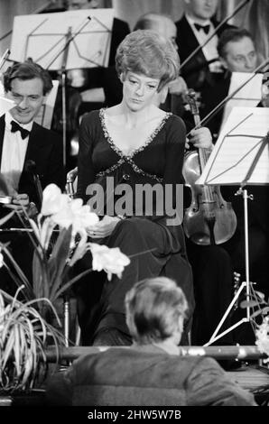 Actress Maggie Smith pictured during the filming of MGM's comedy 'Hot Millions'. In the film Maggie Smith plays an expectant mother who plays the flute. Watford Town Hall, Hertfordshire. 23rd February 1968. Stock Photo