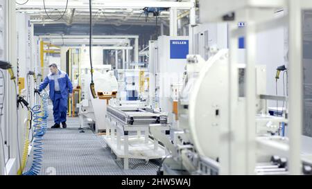 Russia, Moscow - October, 2019: Worker checks processes in modern equipped enterprise. Scene. Factory worker checks and monitors maintenance of shop w Stock Photo