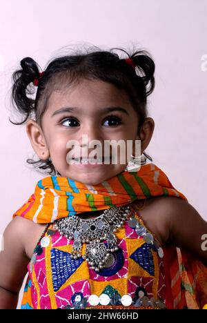 Mumbai Maharashtra India Asia Oct. 04 2009 Beautiful eight years old indian girl playing Dandiya Raas smiling wearing colorful traditional Dress. Stock Photo