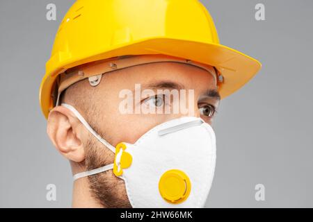 male worker or builder in helmet and respirator Stock Photo