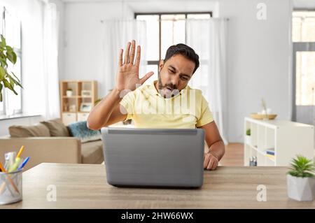 man with laptop has video chat and makes high five Stock Photo