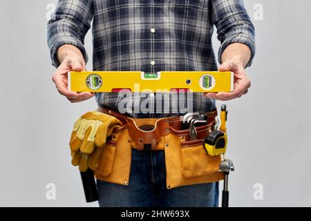 male builder with level and working tools on belt Stock Photo