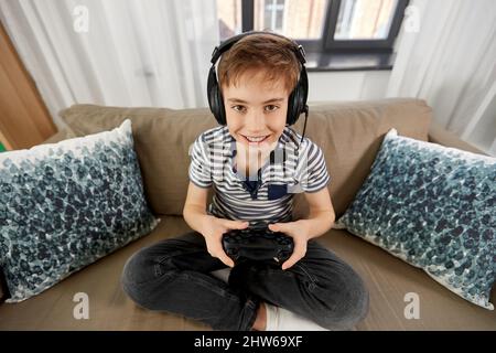 boy with gamepad playing video game at home Stock Photo