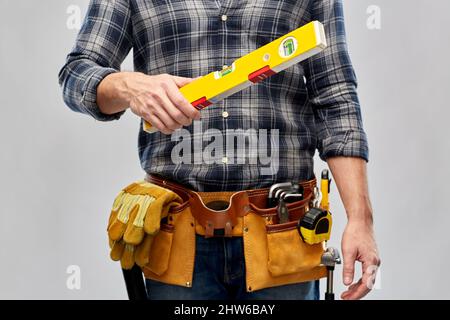 male builder with level and working tools on belt Stock Photo