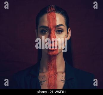 It takes courage to grow up and become who you really are. Studio shot of a young woman posing with paint on her face on a black background. Stock Photo