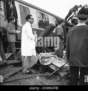 A doctor waits for fire fighters to free victims from the wreckage of the Hixon rail disaster. The accident occurred after a Inter-City train which crashed into a giant transformer on the level crossing at Hixon near Stafford on Saturday (6-1-68). In the crash eleven people were killed and forty injured. 6th January 1968 Stock Photo