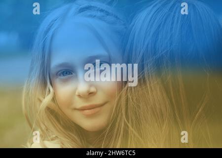 Kiev, Ukraine, February 26, 2022. NO war in Ukraine and world peace. Portrait of a young girl in the arms of her sister on a yellow and blue Ukraine Stock Photo