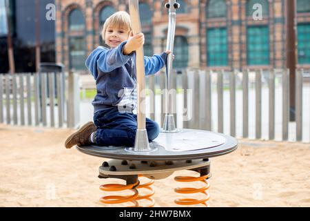 Cute little child, playing on a playground in Barcelona city, family travel with kids in Spain Stock Photo