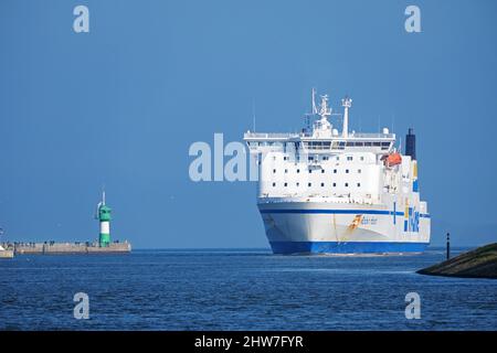 Lubeck, Germany, March 3, 2022: Large ferry boat between the lighthouse and the Priwall shore entering the port of Lubeck Travemunde on the Baltic sea Stock Photo