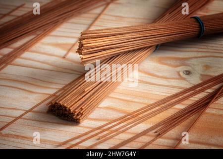 Wholemeal spaghetti, healthy pasta alternative from whole grain durum wheat on a light wooden table, copy space, selected focus, narrow depth of field Stock Photo