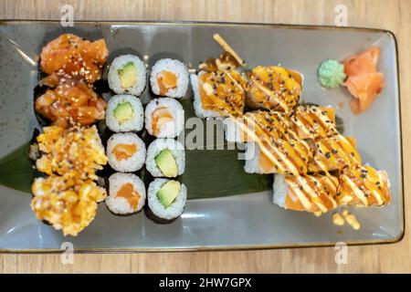 Plate with sushi and noodles on a table in a restaurant, dinnertime Stock Photo