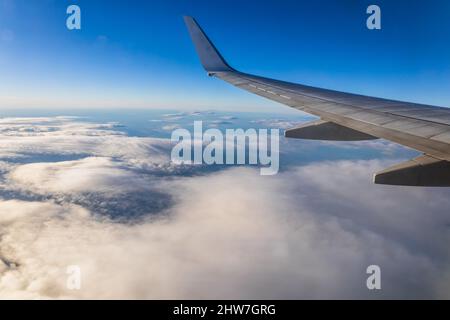 The view of the horizon line across the blue sky on the airplane during the evening day light Stock Photo