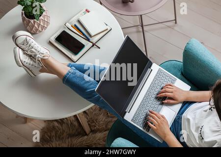 Young woman using laptop screen blank, mock up, work home, top view Stock Photo