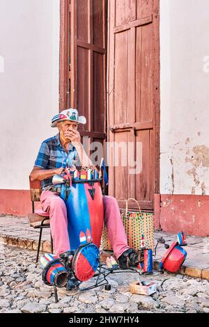 Local senior man playing handmade drum kit, harmonica on street of old colonial town Trinidad, Cuba Stock Photo