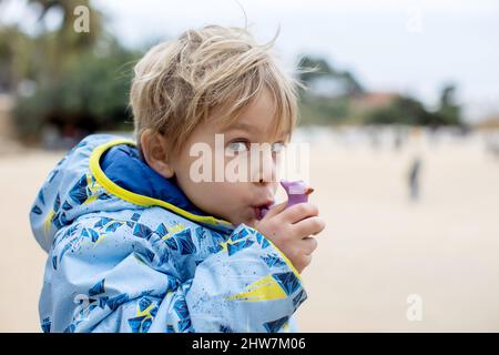 Child, cute boy, playing with ceramic clay whistle in the form of bird, souvenir from park Guell in Barcelona, Spain Stock Photo