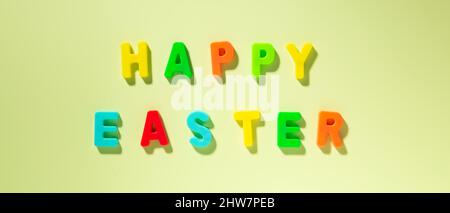 Banner with text multicolored HAPPY EASTER on green background. Easter greeting card Stock Photo