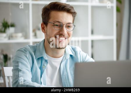 An attractive young man is working on a laptop. Stock Photo