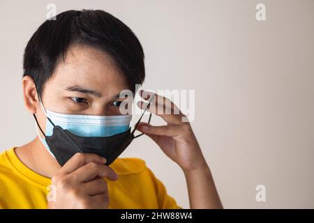 Double masking helps to improve the fit and filtration of first mask. Protection global pandemic of coronavirus. Other name of this disease calls COVI Stock Photo