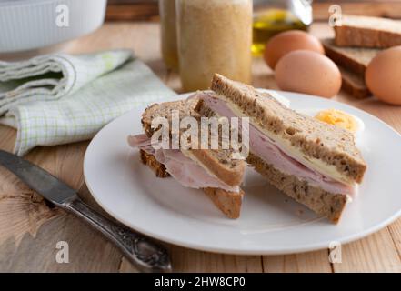 Homemade breakfast sandwich with butter, ham and cheese. Served on multigrain bread Stock Photo