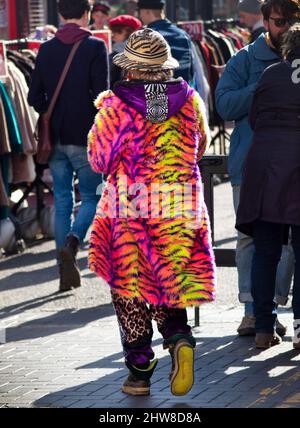 A loud, colorful coat is worn in central Brighton Stock Photo