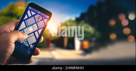Tourist hand using GPS map navigation on smartphone application screen for direction to destination address in the city with travel and technology con Stock Photo