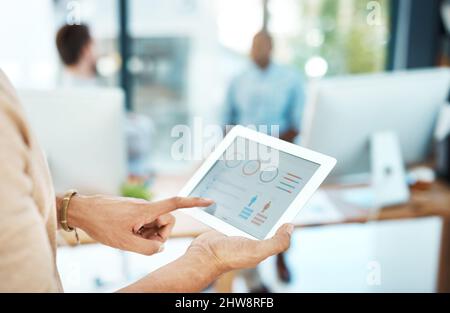 Always up-to-date with the latest software. Cropped shot of a businesswoman using her digital tablet in the office. Stock Photo