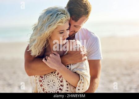 You deserve to escape every once a while. Cropped shot of n affectionate couple spending the day at the beach. Stock Photo