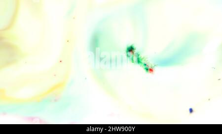 Colorful powder paint on milk. Close-up of powder paint floating moves on surface of white liquid. Crushed colorful pastel paint for art. Stock Photo