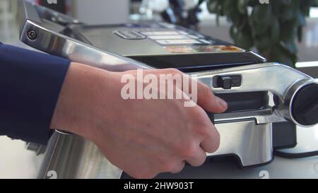 Electric grill press. Household utensils. Close-up of man lifting lid of brand-new electric grill. Modern design with metal body for electric grill pr Stock Photo