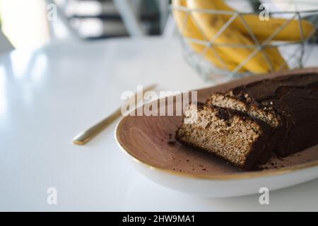 banana bread on the table with kitchen knife and paper Stock Photo