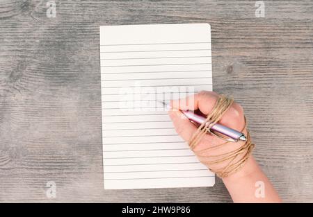 World Press Freedom Day is standing on a paper, hand with pen is chained, free speech, cancel culture, journalist writing Stock Photo