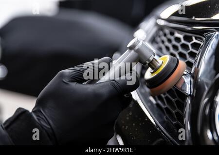 Car detailing technician polishing chrome shine decor on car Stock Photo