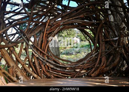 Treebones Twig Hut handmade with woven branches, built by a Big Sur artist, overlooking the vast Pacific Ocean, coastline and Big Sur, California, USA Stock Photo