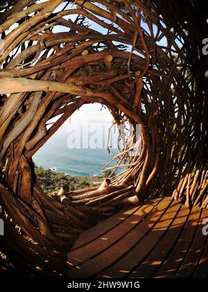 Treebones Twig Hut handmade with woven branches, built by a Big Sur artist, overlooking the vast Pacific Ocean, coastline and Big Sur, California, USA Stock Photo