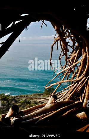 Treebones Twig Hut handmade with woven branches, built by a Big Sur artist, overlooking the vast Pacific Ocean, coastline and Big Sur, California, USA Stock Photo