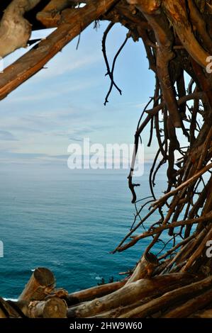 Treebones Twig Hut handmade with woven branches, built by a Big Sur artist, overlooking the vast Pacific Ocean, coastline and Big Sur, California, USA Stock Photo