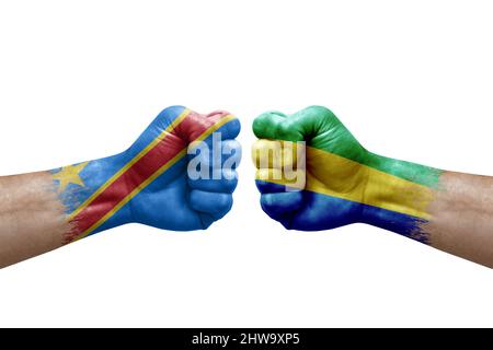 Two hands punch to each others on white background. Country flags painted fists, conflict crisis concept between dr congo and gabon Stock Photo