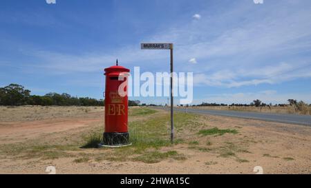 A British Mail post box makes an unusual letter box for a farm on the corner on a remote and empty road in outback Australia Stock Photo