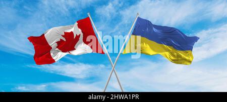 Canada and Ukraine national flags waving in wind against cloudy sky ...