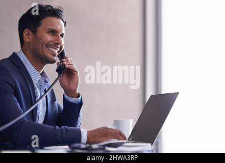 Hes working hard to complete his tasks. Cropped shot of a handsome young businessman working at his desk. Stock Photo