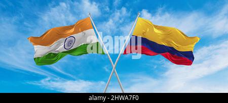 crossed national flags of India and Colombia flag waving in the wind at cloudy sky. Symbolizing relationship, dialog, travelling between two countries Stock Photo