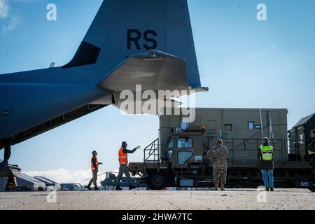 Lithuania. 27th Feb, 2022. U.S. joint service members work alongside Lithuanian military members to unload cargo from a C-130J Super Hercules assigned to Ramstein Air Base, Germany in Lithuania, Feb. 27, 2022. The 86th Airlift Wingâ C-130Js are currently enabling the movement of equipment and personnel throughout Eastern Europe. Credit: U.S. Air Force/ZUMA Press Wire Service/ZUMAPRESS.com/Alamy Live News Stock Photo