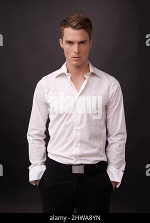 Mesmerized by you. Portrait of a handsome young man standing with his hands in his pockets. Stock Photo