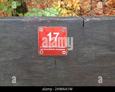 Emergency call sign on a bench in forest, Germany Stock Photo